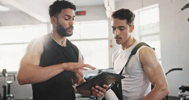 Trainer and client reviewing health diagnostics for personalized coaching from labs