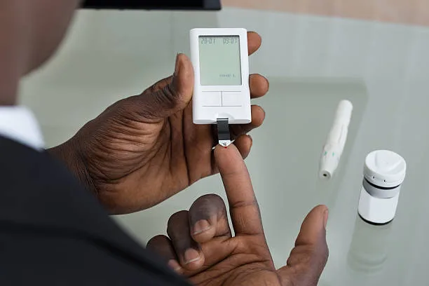Man checking blood sugar and cholesterol levels using a digital monitor