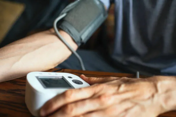 Person measuring blood pressure, related to cholesterol and headache risk