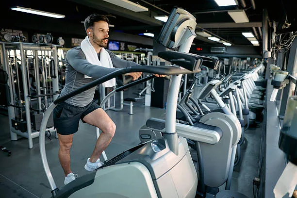 Individual climbing stairs on a stair climber machine with focus and determination
