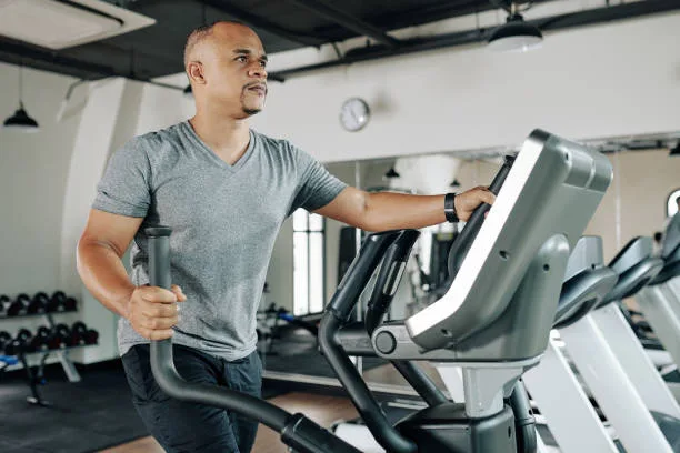 Man performing low-intensity cardio on an elliptical machine during bulking