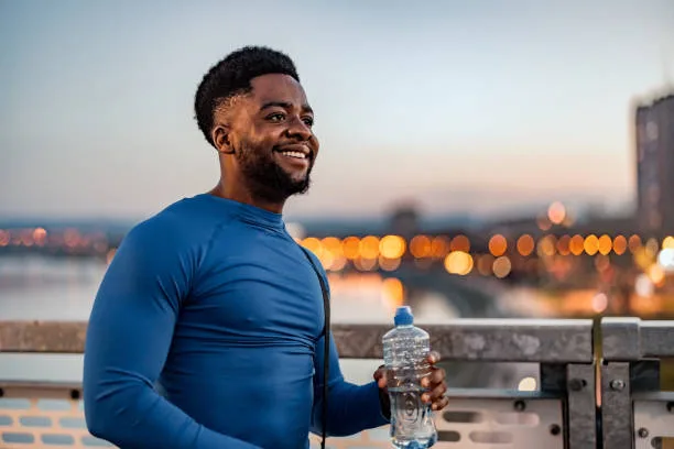 Person holding a water bottle, taking a break from running 