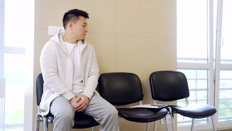 Person calmly waiting in a bright clinic room before a fasting blood draw